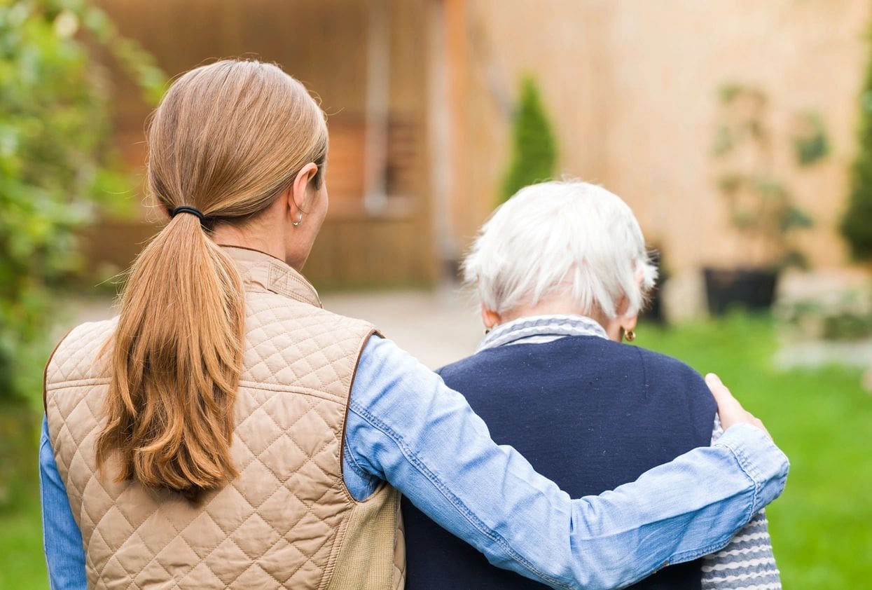 A woman and an old man are standing outside