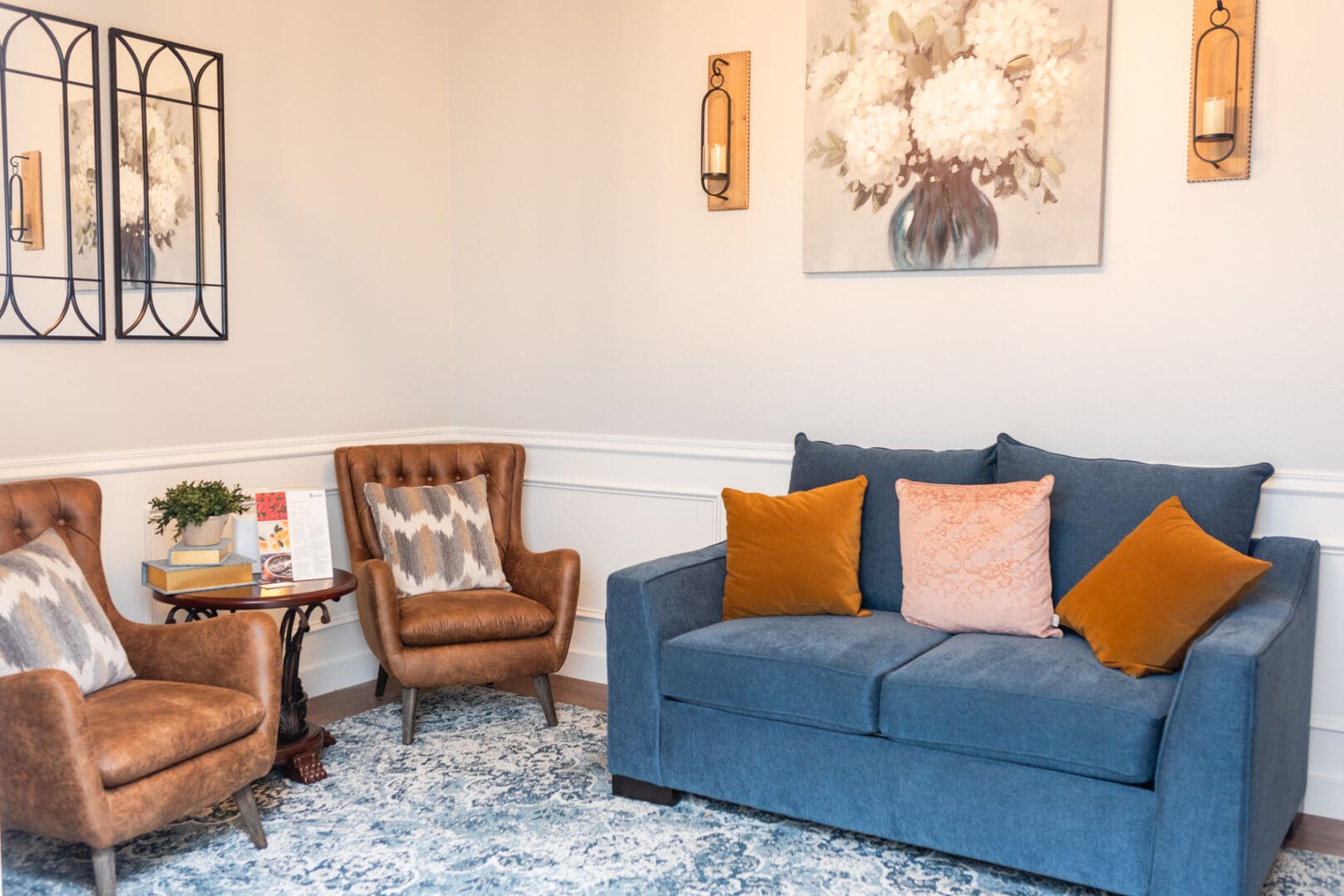 A living room with blue couch and two chairs